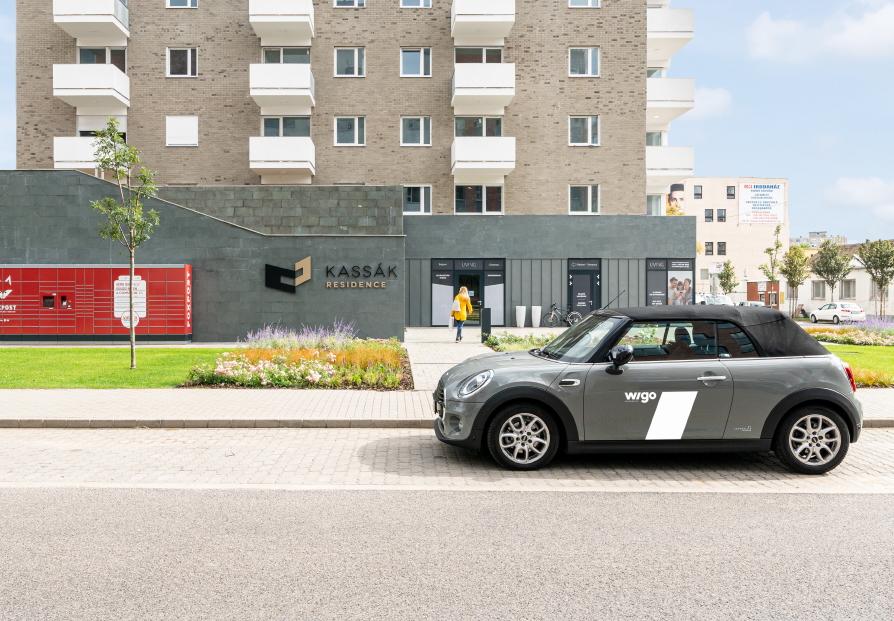 Közösségi autómegosztással igénybevehető autó a lakópark előtt