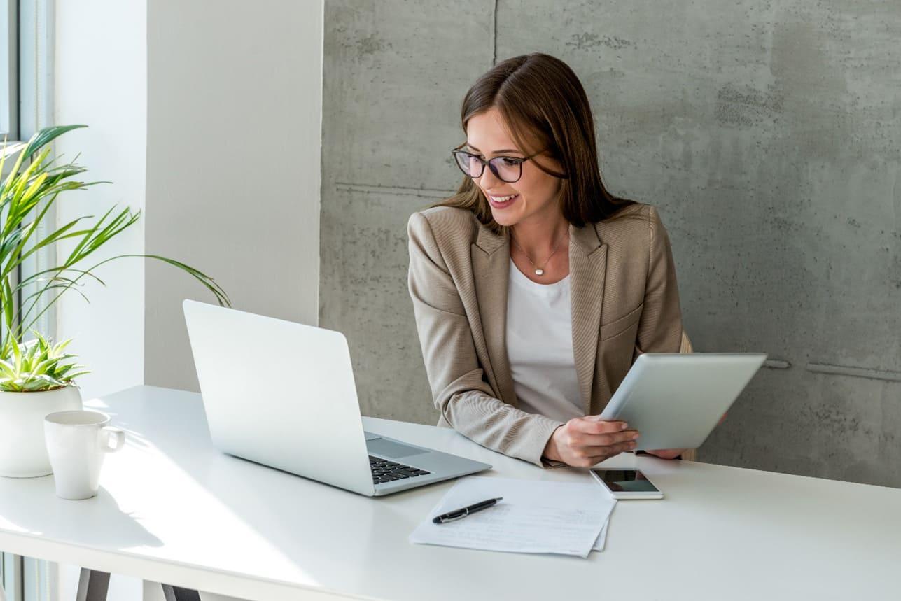 Elemző nő ül az asztalnál a laptop előtt